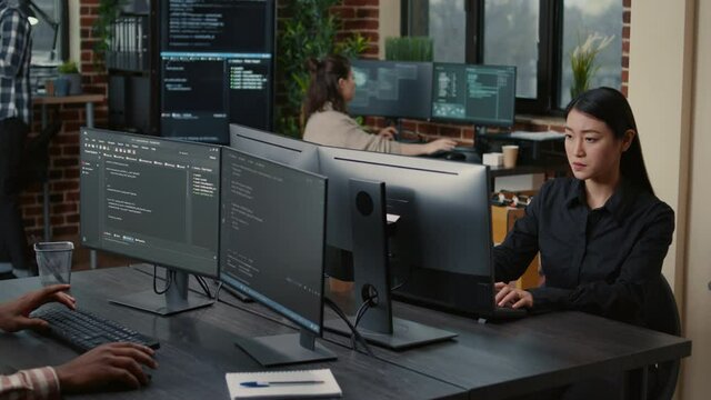 IT support specialists monitoring computer systems in a Singapore office