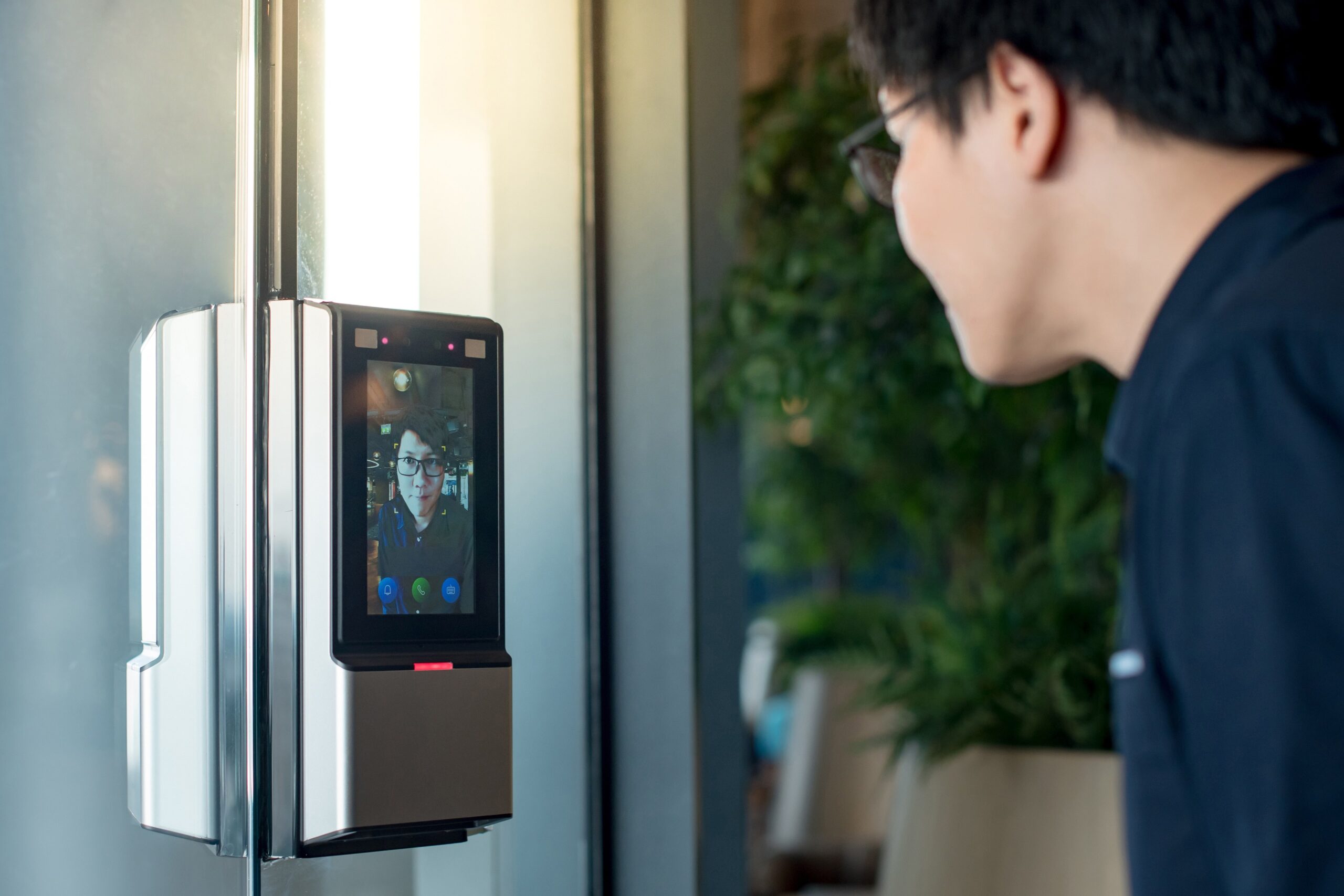 Technician using facial recognition access control system at office entrance in Singapore