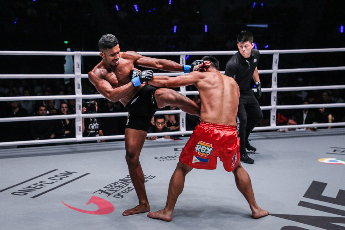 Professional MMA fighters practicing striking techniques inside a martial arts training cage.