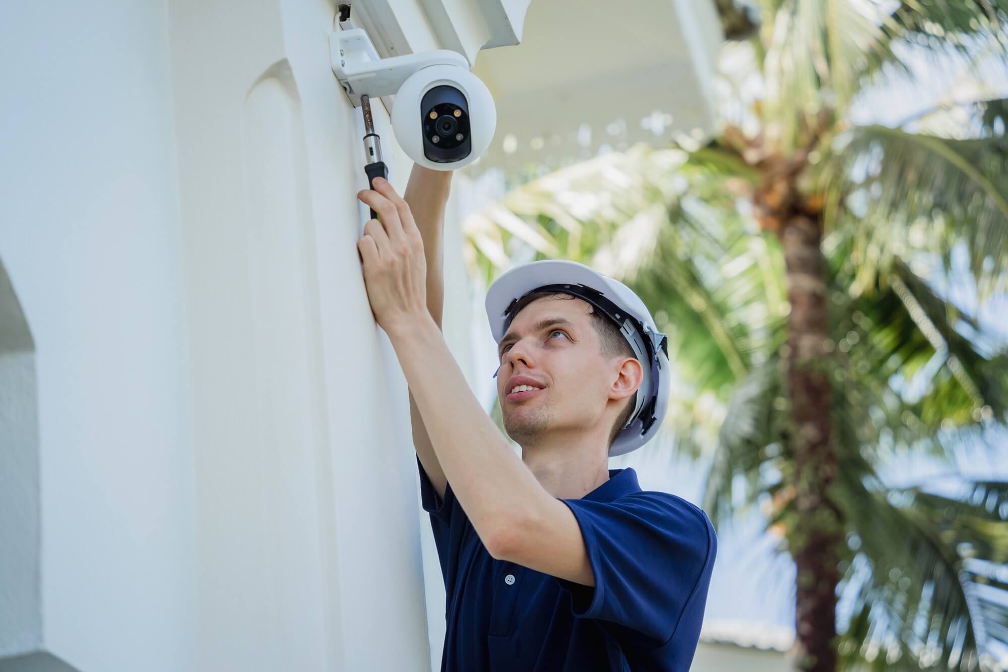 Security technician installing a CCTV camera outside a building