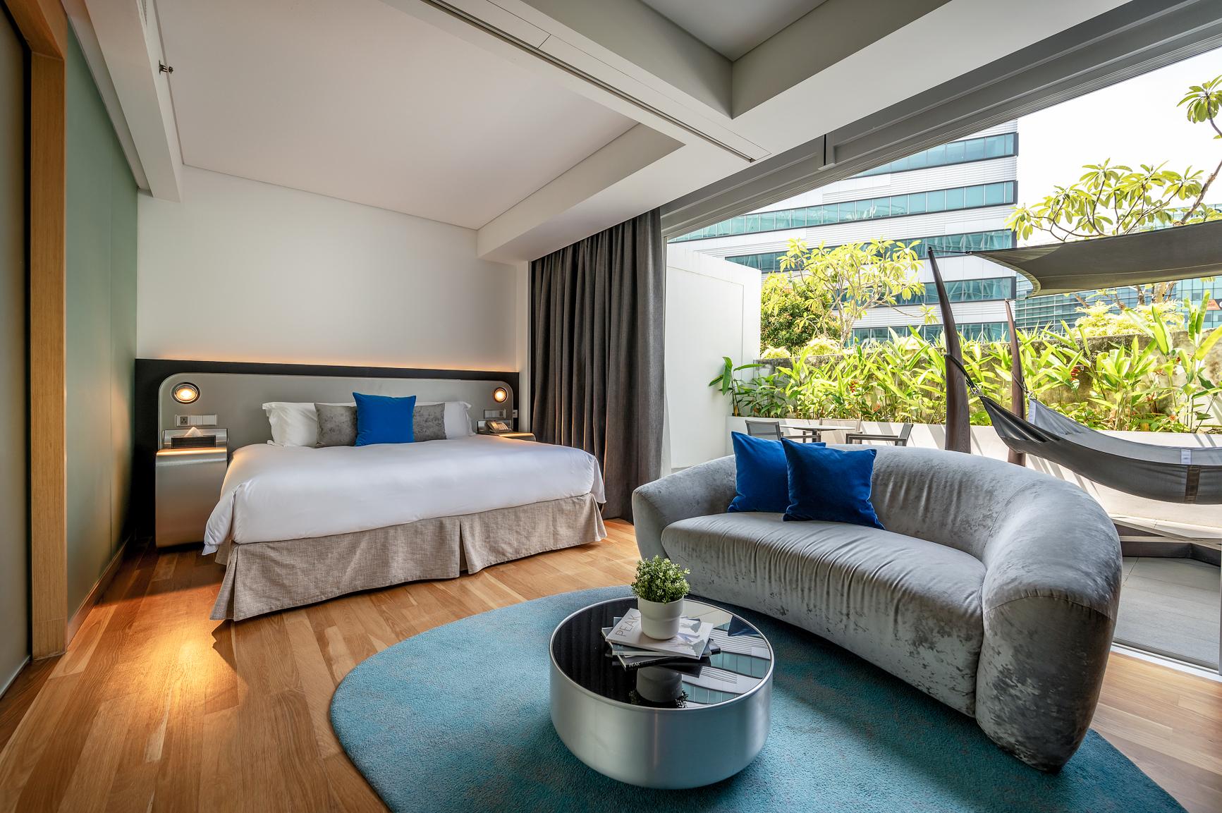 Boutique staycation hotel room with lounge area and large windows